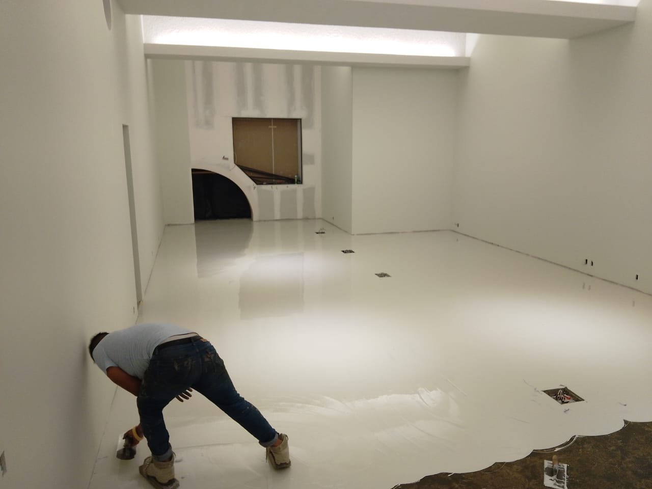 Aplicación de sistema epóxico autonivelante blanco sobre concreto desbastado